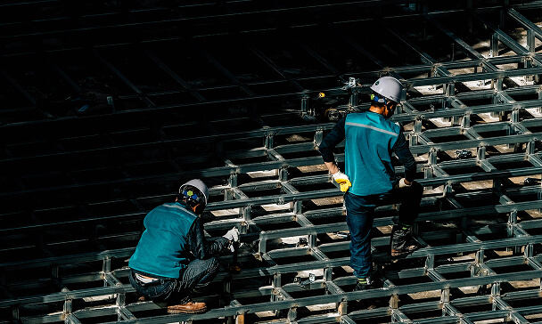 Construction Workers on Metal Grid Structure